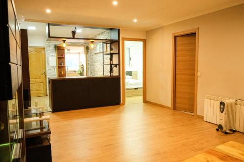 a living room with a door and a wooden floor at Alojamiento Pichi in Vigo