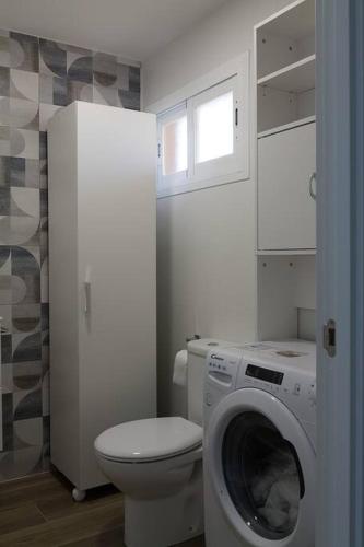 a bathroom with a toilet and a washing machine at lacaletasol in Villajoyosa