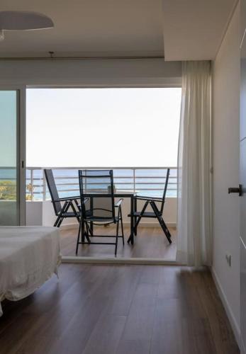 a bedroom with a balcony with a table and chairs at lacaletasol in Villajoyosa