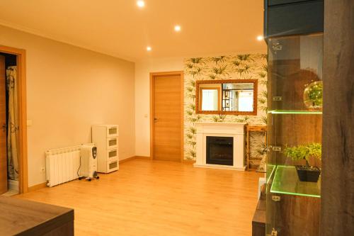 uma sala de estar com lareira e pisos em madeira em Alojamiento Pichi em Vigo
