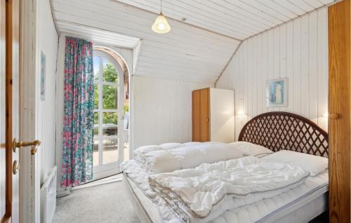 Schlafzimmer mit einem großen weißen Bett und einem Fenster in der Unterkunft Awesome Home In Ulfborg With Kitchen in Fjand Gårde