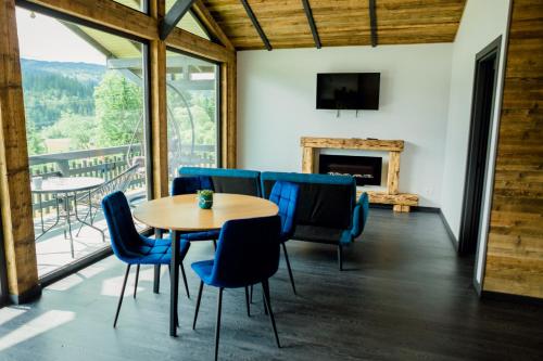 une salle à manger avec une table, des chaises et une cheminée dans l'établissement Tiny House Todireni, à Vatra Dornei