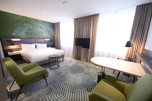 a hotel room with a bed and two chairs at Mercure Warszawa Grand in Warsaw