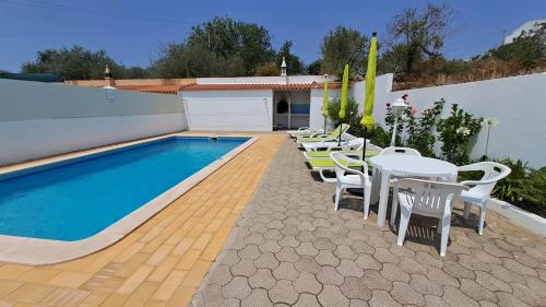 a swimming pool with tables and chairs next to a building at Albufeira Traditional Apartments IN VILLA in Albufeira