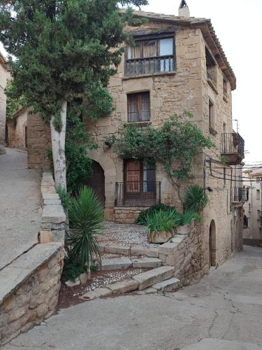 an old stone house with stairs in front of it at Casa Rural La Gineta in Calaceite