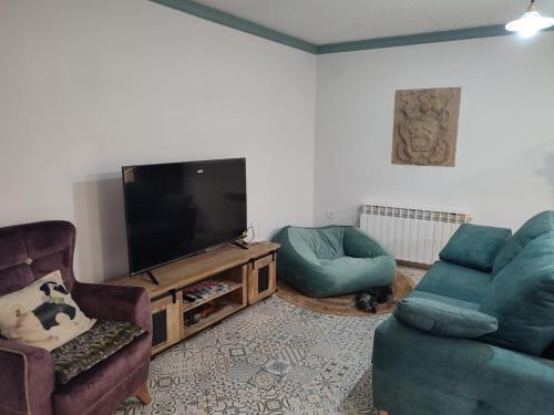 a living room with two chairs and a television at Casa Rural La Gineta in Calaceite