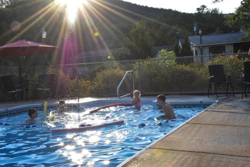 un grupo de niños jugando en una piscina en Adirondack Sunrise Lodge, en Lake George