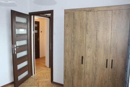 um quarto com dois armários de madeira ao lado de uma porta em Travel Apartament Cracow na Cracóvia