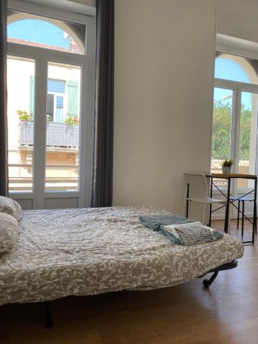 une chambre avec un lit et une grande fenêtre dans l'établissement LA MAISON D'ANTONIN 2, à Nîmes
