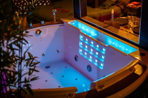een bad met blauwe verlichting in een kamer bij La suite détendue in Saint-Blimont