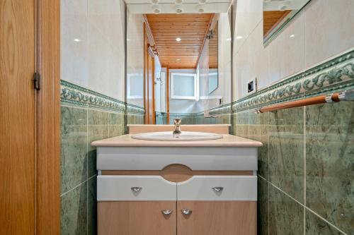 ein Bad mit einem Waschbecken und einem Spiegel in der Unterkunft Odet in Torredembarra