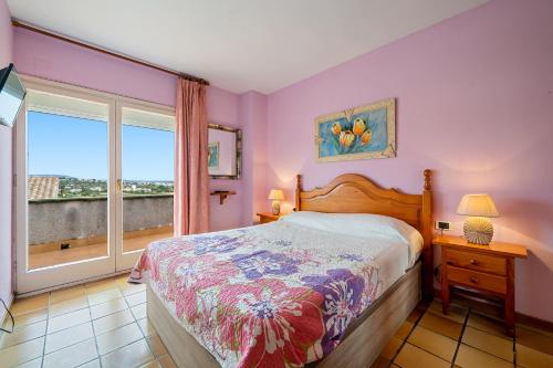 Schlafzimmer mit lila Wänden, einem Bett und einem Fenster in der Unterkunft Odet in Torredembarra
