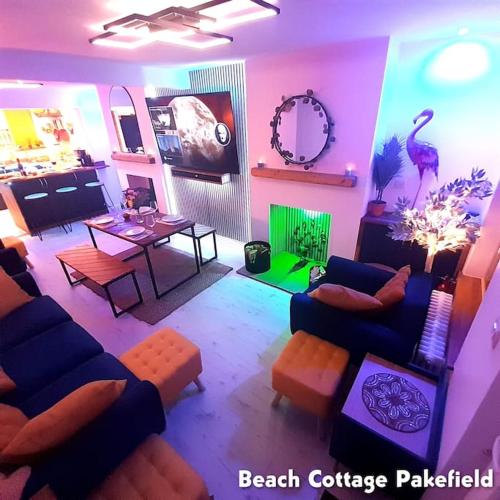 a living room with a blue couch and a table at Beach Cottage Pakefield- Newly Fully Renovated House in Pakefield
