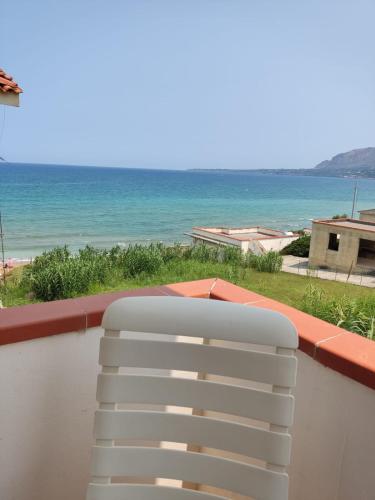 a white chair on a balcony with a view of the ocean at sizilien in Trappeto
