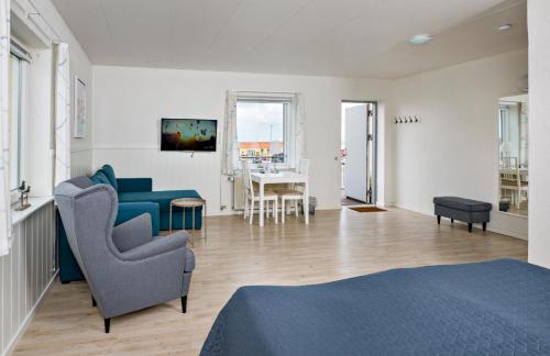 a living room with a blue couch and a chair at Hvalpsund Færgekro in Hvalpsund