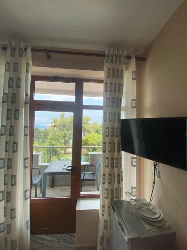 a room with a door open to a patio with a table at Vila Vadeha in Pogradec