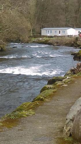 a river with at Stunning 3 Bed Riverside Cabin in Snowdonia in Caeathro