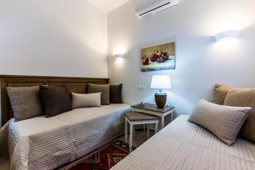 1 dormitorio con 2 camas y mesa con lámpara en Rodia Eco stay house in Epidavros - Akros Estate, en Nea Epidavros