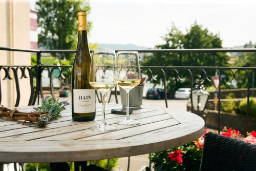 a bottle of wine and two glasses on a table at Weingutshotel Piesporter Goldtröpfchen in Piesport