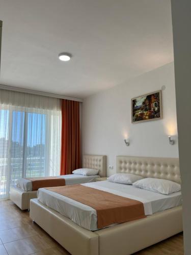 a bedroom with two beds and a large window at Apartments Fati & Flori in Ulcinj