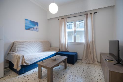 a living room with a couch and a table and a window at Piraeus port 1 bedroom 2 persons apartmet by MPS in Piraeus