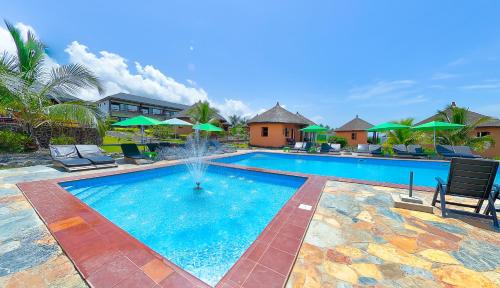 a swimming pool with a fountain in the middle at Lemon Beach Resort in Elmina