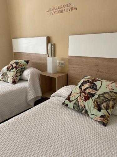 1 Schlafzimmer mit 2 Einzelbetten und einem Nachttisch in der Unterkunft Hotel Valldigna in Tavernes de la Valldigna