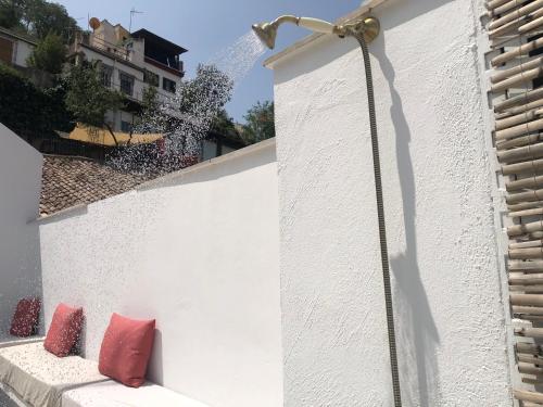 a white wall with two red pillows on it at Amazing Loft! Rooftop Terrace! Alhambra Views! in Granada