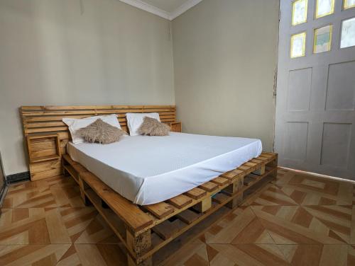 Elizabeth Home في أروشا: غرفة نوم بسرير خشبي في غرفة