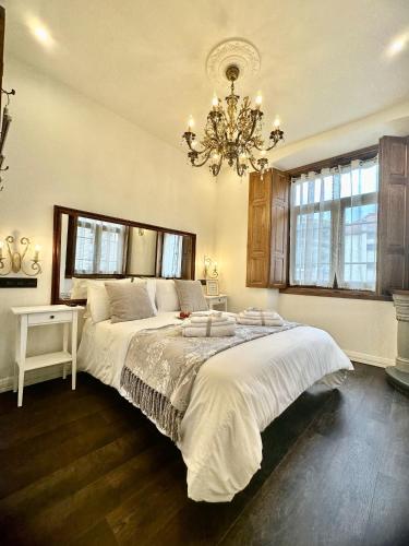 a bedroom with a large bed and a chandelier at CLAREN´S BOUTIQUE ROOMS in Cangas del Narcea