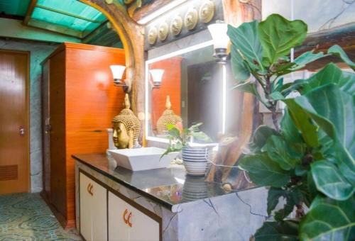 baño con encimera con lavabo y espejo en Delia's Guest House en Isla de Mactán