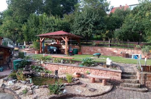 a garden with a pond and a gazebo at Ferienwohnung Hanna in Hausen