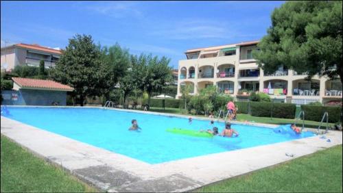 a group of people in a large swimming pool at Apartamento en Platja Sant Pol S'agaro con pisicina y jardin (playa - centro) in Sant Feliu de Guixols