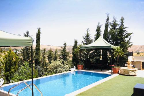 a swimming pool in a yard with a gazebo at Green Farm in Jerash