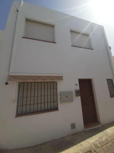 - un bâtiment blanc avec deux fenêtres et une porte dans l'établissement Casa mis Nietas, à San José