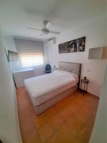a bedroom with a white bed and a window at Casa mis Nietas in San José