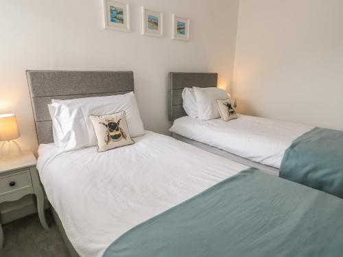 two twin beds in a room with two lamps at Fir Tree Cottage in Caernarfon