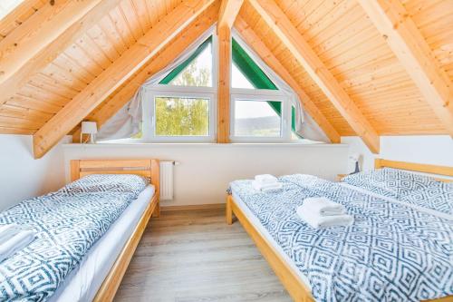 2 camas en una habitación con ventana en Apartmán Riviéra Lipno 510/21, en Lipno nad Vltavou