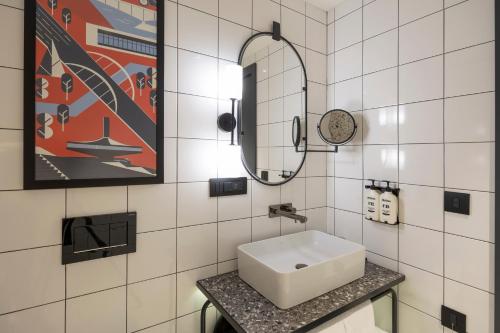 a white bathroom with a sink and a mirror at Hotel Indigo Belgrade by IHG in Belgrade