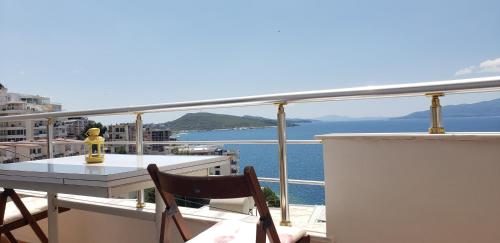 une table et des chaises sur un balcon avec vue sur l'eau dans l'établissement SunSea apartment, à Saranda