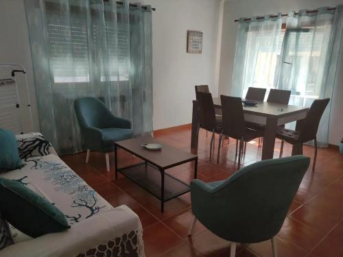 a living room with a table and chairs at Apartamento Bella Vista São Martinho do Porto in São Martinho do Porto