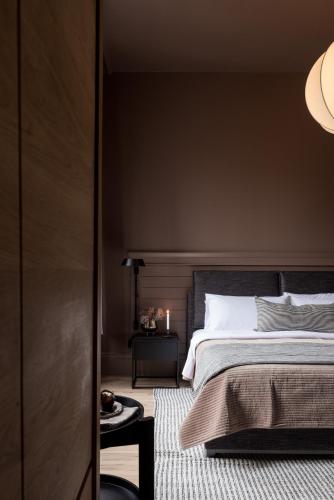 a bedroom with a large bed and a black wall at Dvele Inn in St. John's