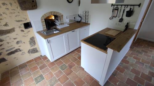 une cuisine avec un évier et un plan de travail dans l'établissement Petite maison de campagne, à La Bazoge