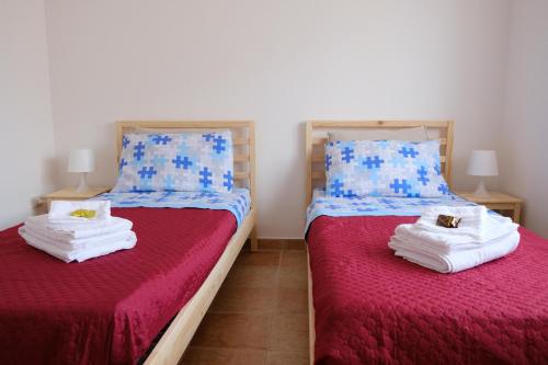 sypialnia z 2 łóżkami z czerwoną pościelą i niebieskimi poduszkami w obiekcie La casa di Dani w mieście Lanciano