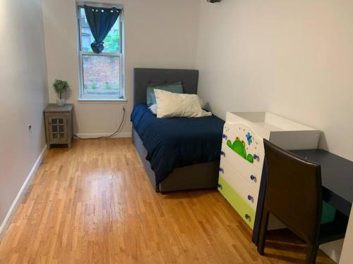 a bedroom with a bed and a dresser and a window at Crown Heights Gem in Brooklyn
