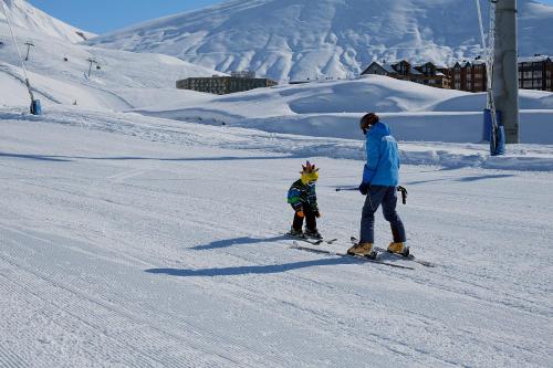 a man and a child on skis in the snow at 2-room Apartment Gudauri Penta 703 in Gudauri