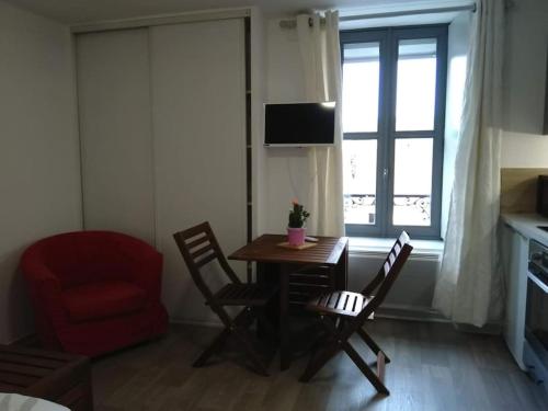 um quarto com uma mesa e cadeiras e uma janela em Arbois: très beau studio place de la Liberté em Arbois