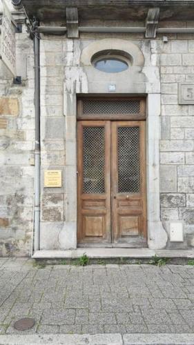 uma porta de madeira na lateral de um edifício em Arbois: très beau studio place de la Liberté em Arbois