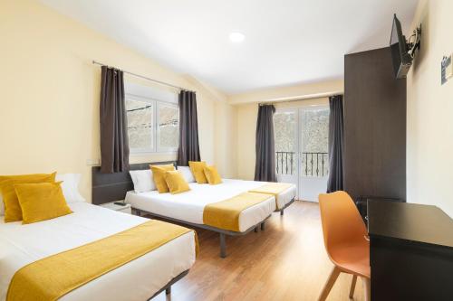 um quarto de hotel com duas camas e uma secretária em Hotel Alda Borox em Borox