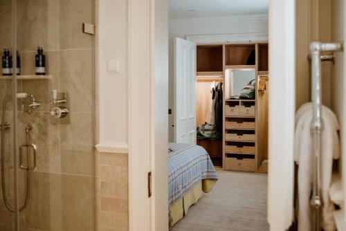 a bathroom with a shower and a bed in a room at Links House at Royal Dornoch in Dornoch